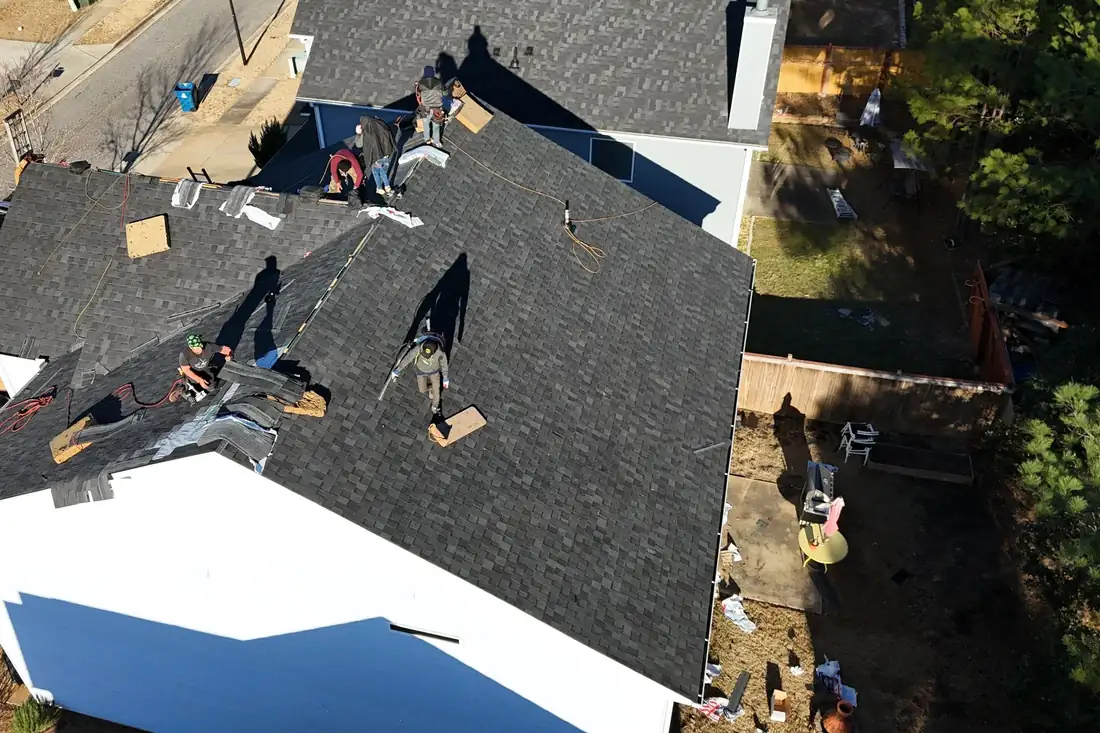 Roofing crew installing new shingles